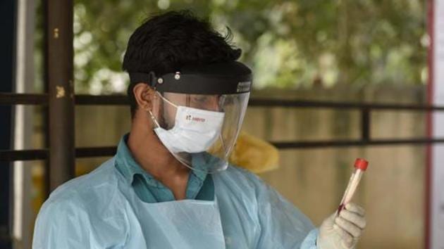 A medical worker holds up a swab sample collected for RT-PCR coronavirus testing at the Polyclinic in Sector 31, Gurugram, India, on Wednesday.(Parveen Kumar/HT Photo) A medical worker holds up a swab sample collected for RT-PCR coronavirus testing at the Polyclinic in Sector 31, Gurugram, India, on Wednesday.(Parveen Kumar/HT Photo)