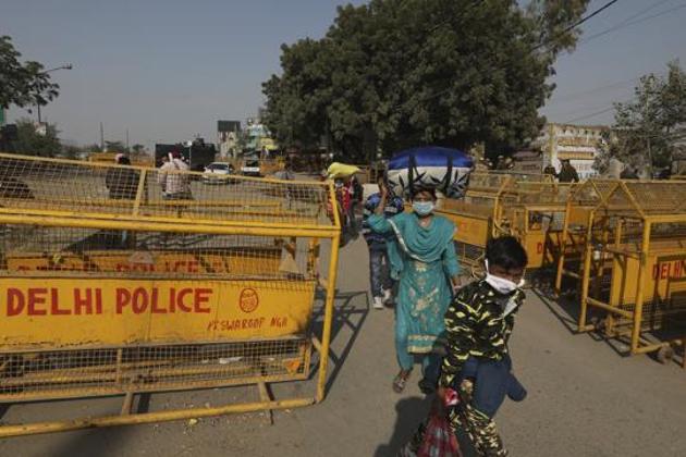 A family walks past a police barricade as farmers block the Delhi-Haryana state border,(AP)