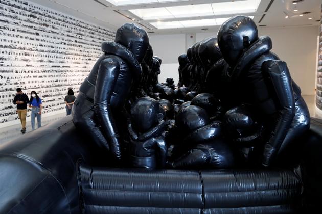 Law of the Journey, looming over the spectators is an inflatable boat inspired by the boats used by refuges, who brave the treacherous seas in order to reach Europe. (REUTERS/Jorge Silva)