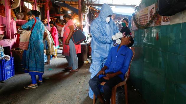 A health worker in personal protective equipment (PPE) collects a swab sample from a man during a rapid antigen testing campaign for the coronavirus disease at a vegetable market.(REUTERS) A health worker in personal protective equipment (PPE) collects a swab sample from a man during a rapid antigen testing campaign for the coronavirus disease at a vegetable market.(REUTERS)