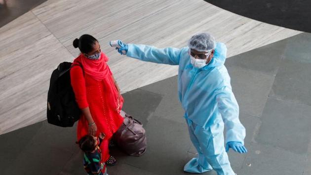 A health worker in personal protective equipment (PPE) checks the temperature of a passenger at a railway station, amid the spread of the coronavirus disease (Covid-19), in Mumbai on November 27, 2020.(Reuters File Photo) A health worker in personal protective equipment (PPE) checks the temperature of a passenger at a railway station, amid the spread of the coronavirus disease (Covid-19), in Mumbai on November 27, 2020.(Reuters File Photo)