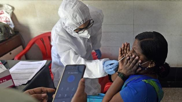 A health worker collects swab sample of a resident at Malad (East) on Monday.(Satyabrata Tripathy/HT Photo) A health worker collects swab sample of a resident at Malad (East) on Monday.(Satyabrata Tripathy/HT Photo)
