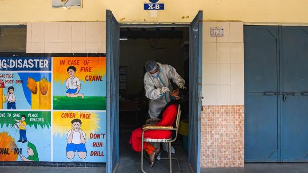 A health worker in PPE coveralls collects a swab sample for coronavirus testing, at Ambedkar Nagar in New Delhi. (Amal KS/HT PHOTO) A health worker in PPE coveralls collects a swab sample for coronavirus testing, at Ambedkar Nagar in New Delhi. (Amal KS/HT PHOTO)