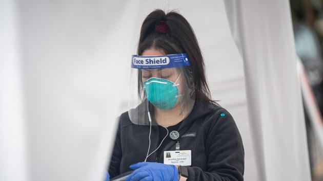 A healthcare worker wearing personal protective equipment (PPE) carries a laboratory transport bag at a drive-thru Covid-19 testing site in Martinez, California, US.(Bloomberg) A healthcare worker wearing personal protective equipment (PPE) carries a laboratory transport bag at a drive-thru Covid-19 testing site in Martinez, California, US.(Bloomberg)