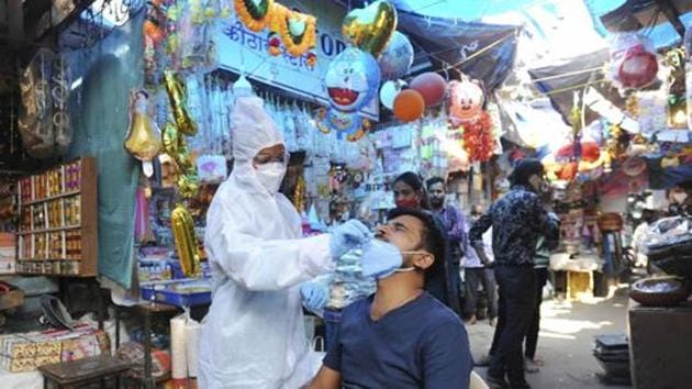 A health worker collects a sample for the Covid-19 test, at a market in Mumbai. (File photo) A health worker collects a sample for the Covid-19 test, at a market in Mumbai. (File photo)