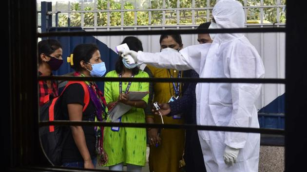 BMC medical staff thermal screening travellers arriving from Gujarat at Dadar Station in Mumbai on December 1. According to BMC health data, 3.68 lakh tests were conducted between October 1 and 28, compared to 3.48 lakh tests in the same period during November. In the same period, the case positivity rate also came down from 12% to 6%. (Anshuman Poyrekar / HT Photo)