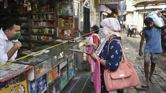 Health department workers interact with a shopkeeper during a door to door survey in Mumbai on December 1. The city has recorded a sharp decline new cases month-on-month. Between November 1 and 28, 23,476 cases were reported, compared to 46,620 cases during the same period in October. (Kunal Patil / PTI)