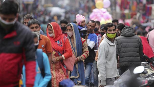 Indians, most of them, wearing face masks as a precautionary measure against the coronavirus crowd a Sunday market in Jammu, India.(AP)