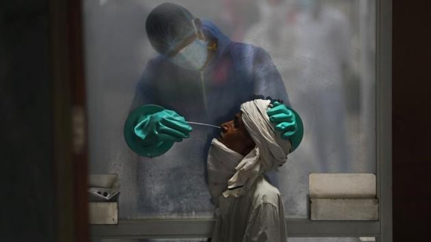 A healthcare worker takes a nasal swab of a person for a Covid-19 test at a hospital in New Delhi.(AP File Photo) A healthcare worker takes a nasal swab of a person for a Covid-19 test at a hospital in New Delhi.(AP File Photo)