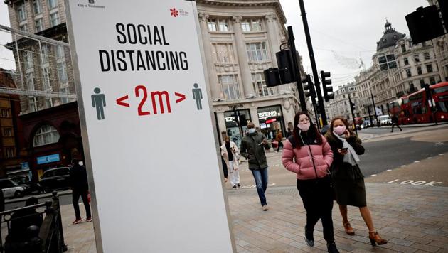 Pedestrians walk past a Covid-19 information sign asking people to social distance in central London, on November 27, 2020.(AFP photo) Pedestrians walk past a Covid-19 information sign asking people to social distance in central London, on November 27, 2020.(AFP photo)
