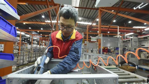 A worker installs a power distribution cabinet in a subsidiary of the State Grid in Hangzhou in east China's Zhejiang province.(AP) A worker installs a power distribution cabinet in a subsidiary of the State Grid in Hangzhou in east China's Zhejiang province.(AP)