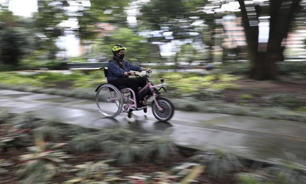 A tourist rides an electric wheelchair during a tour in Medellin, Colombia, Wednesday, Nov. 18, 2020. The steering and breaks on the wheelchairs are like those on a regular bicycle, while accelerating only requires pushing a button on one of the handles. (AP) A tourist rides an electric wheelchair during a tour in Medellin, Colombia, Wednesday, Nov. 18, 2020. The steering and breaks on the wheelchairs are like those on a regular bicycle, while accelerating only requires pushing a button on one of the handles. (AP)