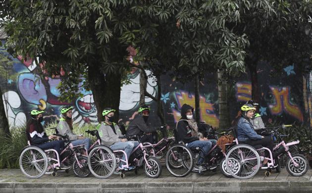 Tourists in electric wheelchairs ride at a park in Medellin, Colombia, Wednesday, Nov. 18, 2020. (AP) Tourists in electric wheelchairs ride at a park in Medellin, Colombia, Wednesday, Nov. 18, 2020. (AP)