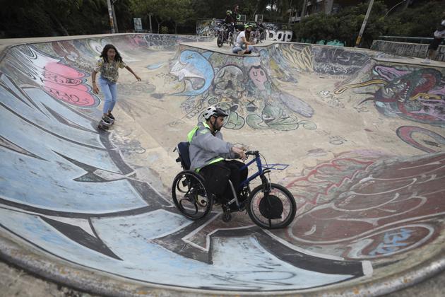 Martin Londoño, right, owner of MATT, an electric wheelchair tour company, rides his wheelchair at a skate park in Medellin, Colombia, Wednesday, Nov. 18, 2020. Londoño says he is trying to promote his tour on social media while building partnerships with local travel companies. He dreams of taking the wheelchair tours to other cities in Colombia, Latin America and the United States. (AP) Martin Londoño, right, owner of MATT, an electric wheelchair tour company, rides his wheelchair at a skate park in Medellin, Colombia, Wednesday, Nov. 18, 2020. Londoño says he is trying to promote his tour on social media while building partnerships with local travel companies. He dreams of taking the wheelchair tours to other cities in Colombia, Latin America and the United States. (AP)