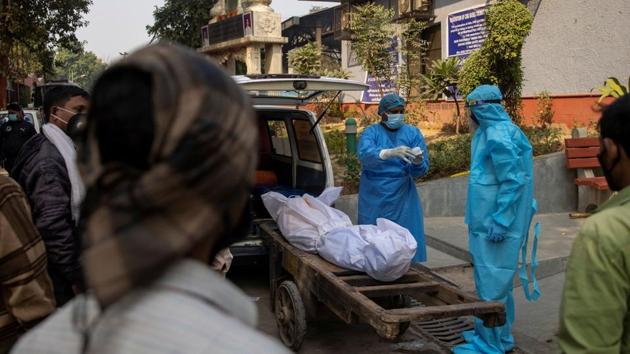 A health worker speaks to the relative of a Covid-19 victim, before the cremation in New Delhi on November 13.(File photo)