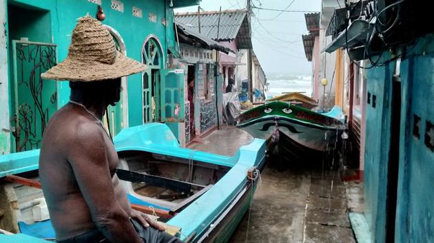 A fisherman sits on the top of a boat after pulling it back to land as the cyclone Burevi is expected to near the coast of Trincomalee, Sri Lanka December 2, 2020.(Reuters photo) A fisherman sits on the top of a boat after pulling it back to land as the cyclone Burevi is expected to near the coast of Trincomalee, Sri Lanka December 2, 2020.(Reuters photo)