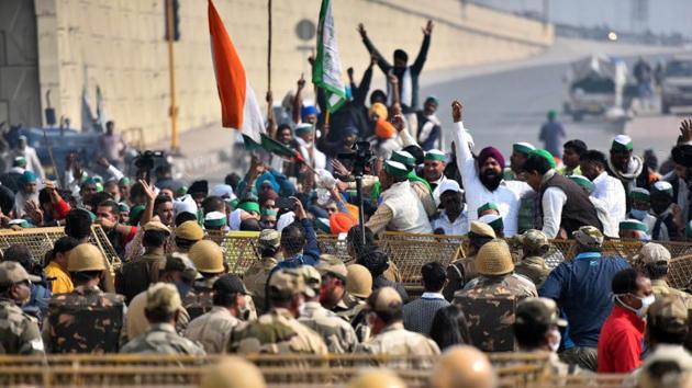 Farmers protest across police barricades at the Delhi-Ghazipur Border, in New Delhi on December 1. While the farmers want the three farm laws approved by Parliament in September to be revoked, the government has leaned on its new reform agenda for better crop prices and higher investments in the farm sector. (Raj K Raj / HT Photo)