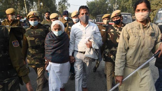 Bilkis Bano, a demonstrator who rose to prominence during the Shaheen Bagh anti-CAA NRC protests, is escorted away by police after she arrived to join the farmers’ protest at Singhu Border on December 1. Opposition to the reforms has set off some of the biggest farmers’ protests in decades, HT reported. (Vipin Kumar / HT Photo)