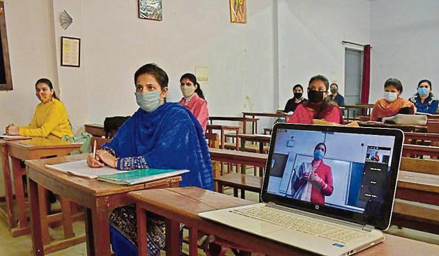 Teachers conducting online and offline classes simultaneously at SCD Government College in Ludhiana on Thursday.(Harsimar Pal Singh/HT)