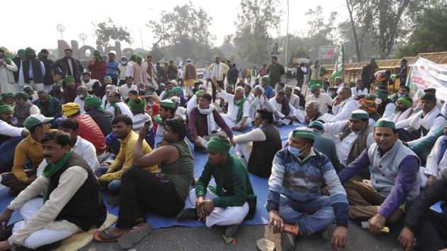 Farmers occupy the road in protest against farm reform laws at Sector 14A Noida gate in Noida on Wednesday.(Sunil Ghosh / HT)