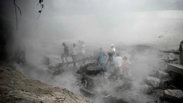 Villagers gather to check the damage caused by lava flow in Lumajang, East Java province, Indonesia on December 2.In late 2018, a volcano in the strait between Java and Sumatra islands erupted, causing an underwater landslide that unleashed a tsunami which killed more than 400 people, AFP reported. (Juni Kriswanto / AFP)