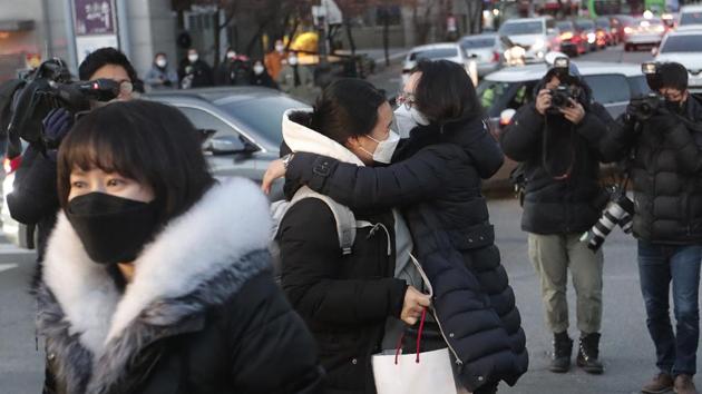 A student hugs her mother, right, before entering a high school to take the college entrance exam in Seoul, South Korea on Thursday, Dec 3, 2020. South Korean officials urged on Wednesday people to remain at home if possible and cancel gatherings as about half a million students prepare for the crucial national college exam.(AP)