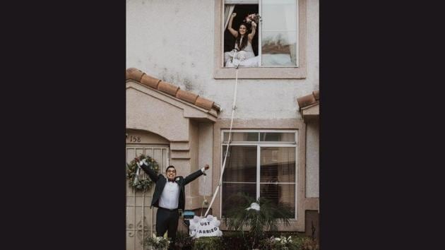 The image shows the bride sitting on the second-story window of a house while the groom is standing on the ground. (Instagram/@jesscaste) The image shows the bride sitting on the second-story window of a house while the groom is standing on the ground. (Instagram/@jesscaste)