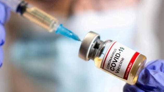 A woman holds a small bottle labeled with a "Coronavirus COVID-19 Vaccine" sticker and a medical syringe in this illustration taken October 30, 2020. REUTERS/File Photo(REUTERS) A woman holds a small bottle labeled with a "Coronavirus COVID-19 Vaccine" sticker and a medical syringe in this illustration taken October 30, 2020. REUTERS/File Photo(REUTERS)