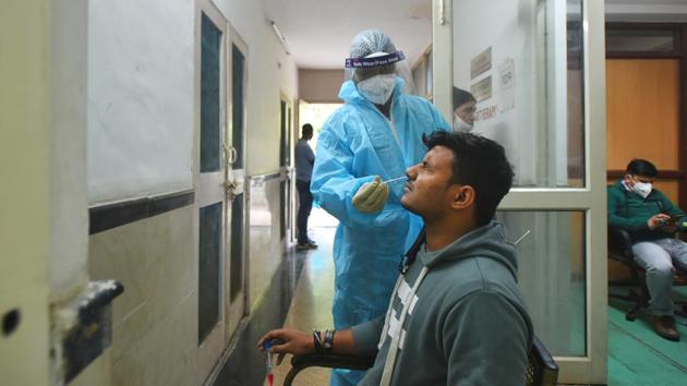 A health worker in PPE kit collects a swab sample from a man to test for Covid-19 infection, at Bengali Market, in New Delhi.(HT photo) A health worker in PPE kit collects a swab sample from a man to test for Covid-19 infection, at Bengali Market, in New Delhi.(HT photo)