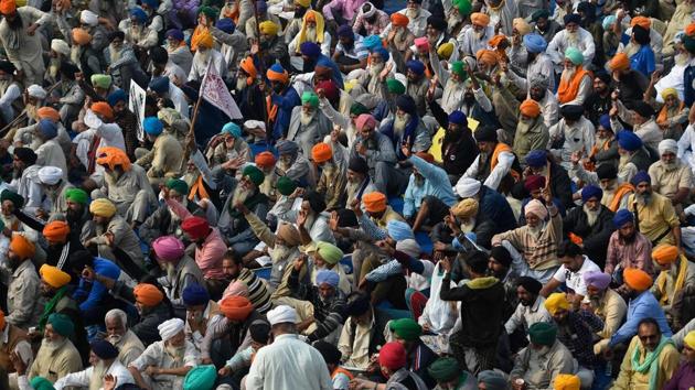 Farmers listen to a speaker as they take part in a protest against the central government’s recent agricultural reforms at the Delhi-Haryana state border in Singhu on Friday.(AFP)