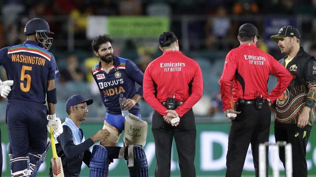 India's Ravindra Jadeja, third left, has a trainer tend to his leg during a break in batting against Australia during their T20 international cricket match at Manuka Oval, in Canberra, Australia, Friday, Dec 4, 2020. (AP Photo/Mark Baker) (AP) India's Ravindra Jadeja, third left, has a trainer tend to his leg during a break in batting against Australia during their T20 international cricket match at Manuka Oval, in Canberra, Australia, Friday, Dec 4, 2020. (AP Photo/Mark Baker) (AP)