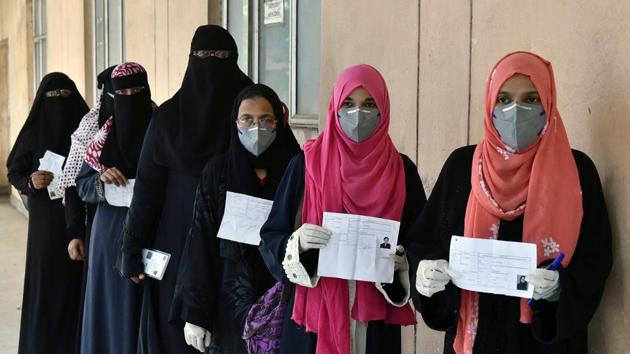 Female voters show their voter ID slips as they stand in a queue to vote for the GHMC election, in Hyderabad on Thursday.(ANI Photo)