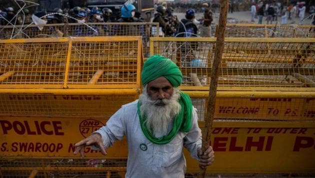 A farmer stands in front of police barricades during a protest against the newly passed farm bills at Singhu border near Delhi, India, December 3, 2020.(Reuters file photo) A farmer stands in front of police barricades during a protest against the newly passed farm bills at Singhu border near Delhi, India, December 3, 2020.(Reuters file photo)