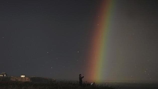 A man makes a photograph of a rainbow, off the coast at Tynemouth, England on November 30. (Owen Humphreys / AP) A man makes a photograph of a rainbow, off the coast at Tynemouth, England on November 30. (Owen Humphreys / AP)