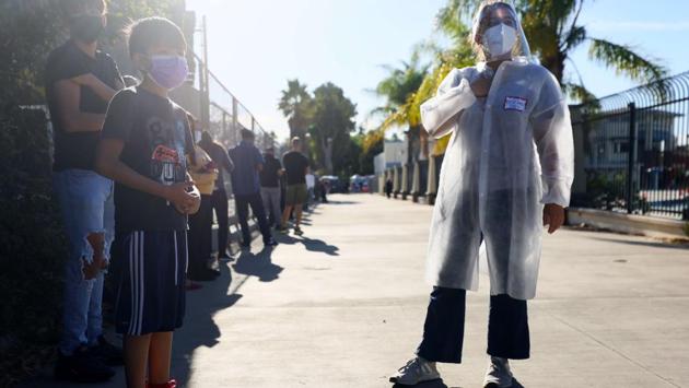 A University of Southern California research team member (R) recruits families to participate in a rapid antigen testing program as people wait in line at a walk-up Covid-19 testing site on December 2 in San Fernando, California. US health officials have warned of a surge after millions of Americans travelled to celebrate last week’s Thanksgiving holiday despite pleas from authorities to stay home. (Mario Tama / Getty Images / AFP) A University of Southern California research team member (R) recruits families to participate in a rapid antigen testing program as people wait in line at a walk-up Covid-19 testing site on December 2 in San Fernando, California. US health officials have warned of a surge after millions of Americans travelled to celebrate last week’s Thanksgiving holiday despite pleas from authorities to stay home. (Mario Tama / Getty Images / AFP)