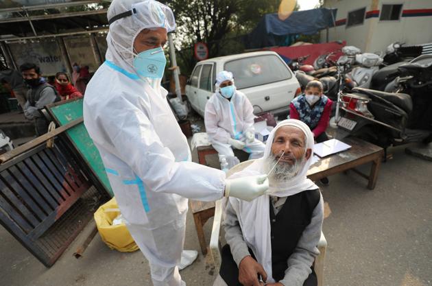 A health worker collects a man’s sample for Covid-19 testing in Jammu on Saturday. (PTI) A health worker collects a man’s sample for Covid-19 testing in Jammu on Saturday. (PTI)