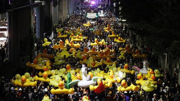Protesters carry inflatable yellow ducks during an anti-government rally while marching towards the base of the 11th Infantry Regiment in Bangkok, Thailand on November 29. (Sakchai Lalit / AP) Protesters carry inflatable yellow ducks during an anti-government rally while marching towards the base of the 11th Infantry Regiment in Bangkok, Thailand on November 29. (Sakchai Lalit / AP)