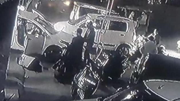 Solanki is seen lying on the ground after he was hit by the first set of bullets fired by assailants standing near the white car. (Stil grab from a sourced CCTV video) Solanki is seen lying on the ground after he was hit by the first set of bullets fired by assailants standing near the white car. (Stil grab from a sourced CCTV video)