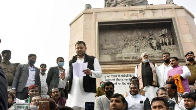 RJD leader Tejashwi Yadav speaks next to the statue of Mahatma Gandhi while on dharna with Congress and RJD workers at Gandhi Maidan in protest against new farm laws, in Patna, Bihar. A case was filed against Yadav and 18 other leaders from the constituents of the Grand Alliance-led opposition in Bihar for protesting without permission amid the coronavirus pandemic.(Photo by Santosh Kumar/ Hindustan Times)