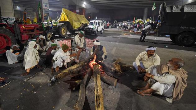 Farmers warm themselves around a bonfire during their protest over the Center's farm reform laws, at Delhi-Noida border near Ghazipur, in New Delhi, Saturday, Dec. 5, 2020.(PTI photo) Farmers warm themselves around a bonfire during their protest over the Center's farm reform laws, at Delhi-Noida border near Ghazipur, in New Delhi, Saturday, Dec. 5, 2020.(PTI photo)