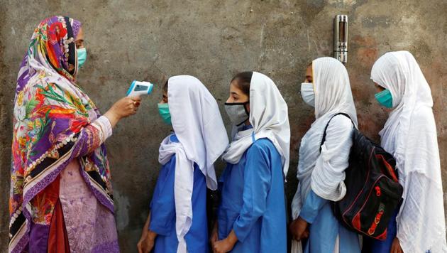 Students wear protective face masks as they have their temperature checked before entering a class, after the government allowed the reopening of schools from grade six to eight amid the coronavirus disease pandemic, in Peshawar on September 23. (Reuters file) Students wear protective face masks as they have their temperature checked before entering a class, after the government allowed the reopening of schools from grade six to eight amid the coronavirus disease pandemic, in Peshawar on September 23. (Reuters file)