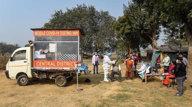 A health worker collects swab sample from residents of Vijay Ghat slum area during a Covid-19 testing camp in New Delhi on December 5. Delhi conducted 73, 536 tests on December 6, recording 2, 706 new cases of Covid-19 — logging a positivity rate of 3.68%, HT reported. (Manvender Vashist / PTI) A health worker collects swab sample from residents of Vijay Ghat slum area during a Covid-19 testing camp in New Delhi on December 5. Delhi conducted 73, 536 tests on December 6, recording 2, 706 new cases of Covid-19 — logging a positivity rate of 3.68%, HT reported. (Manvender Vashist / PTI)