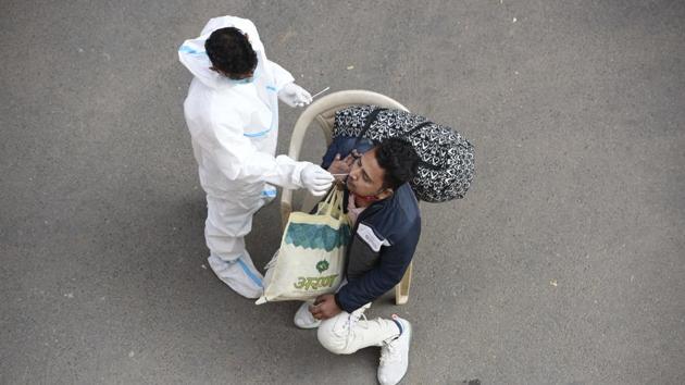 A medical worker collects a swab sample for coronavirus test at IFFCO Chowk, in Gurugram, on December 5.(HT file) A medical worker collects a swab sample for coronavirus test at IFFCO Chowk, in Gurugram, on December 5.(HT file)
