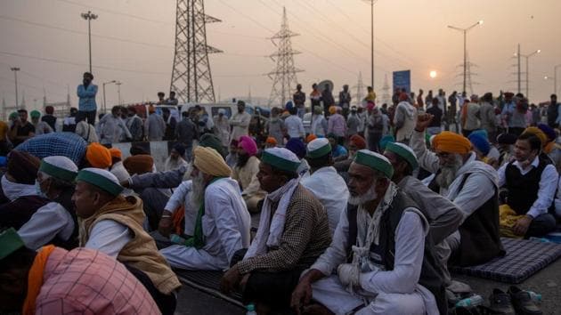 Farmers listen to a speaker on a blocked highway as they attend a protest against the newly passed farm bills at the Delhi-Uttar Pradesh border in Ghaziabad.(REUTERS)