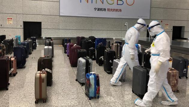 Workers in protective suits sort luggage arriving from India at Ningbo Lishe International Airport in Zhejiang province, China, on September 10.(Reuters file) Workers in protective suits sort luggage arriving from India at Ningbo Lishe International Airport in Zhejiang province, China, on September 10.(Reuters file)