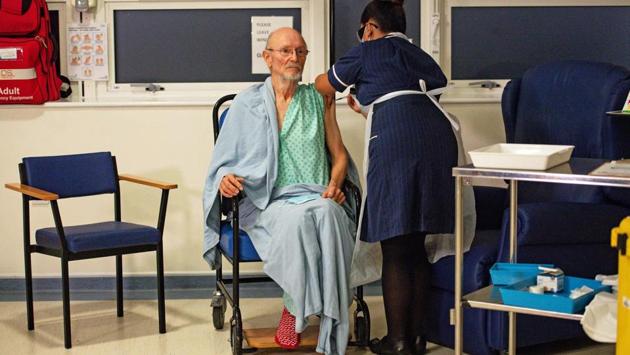 A nurse administers the vaccine to patient William "Bill" Shakespeare (L), 81, who was the second person to receive the shot at University Hospital in Coventry. Britain has received 800,000 doses of the Pfizer vaccine, enough to vaccinate 400,000 people. (Jacob King / Pool / AFP)