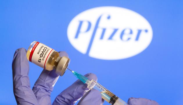 A woman holds a small bottle labelled with a "Coronavirus COVID-19 Vaccine" sticker and a medical syringe in front of displayed Pfizer logo.(Reuters File Photo) A woman holds a small bottle labelled with a "Coronavirus COVID-19 Vaccine" sticker and a medical syringe in front of displayed Pfizer logo.(Reuters File Photo)