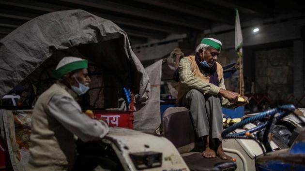 A farmers rests on his tractor parked on a blocked highway during a protest against the newly passed farm bills at the Delhi-Uttar Pradesh border in Ghaziabad.(Reuters Photo) A farmers rests on his tractor parked on a blocked highway during a protest against the newly passed farm bills at the Delhi-Uttar Pradesh border in Ghaziabad.(Reuters Photo)
