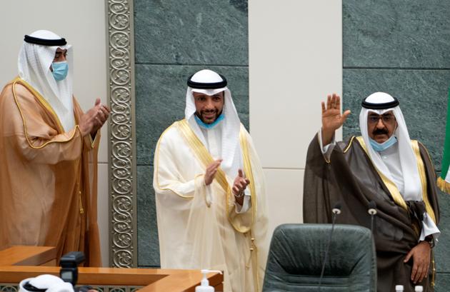 Kuwait's newly appointed crown prince Sheikh Meshal al-Ahmad Al-Jaber al-Sabah waves before he is sworn in, as speaker of parliament Marzouq al-Ghanim, and Kuwait's Prime Minister Sheikh Sabah al-Khalid al-Sabah clap, at the parliament, in Kuwait City.(Reuters) Kuwait's newly appointed crown prince Sheikh Meshal al-Ahmad Al-Jaber al-Sabah waves before he is sworn in, as speaker of parliament Marzouq al-Ghanim, and Kuwait's Prime Minister Sheikh Sabah al-Khalid al-Sabah clap, at the parliament, in Kuwait City.(Reuters)