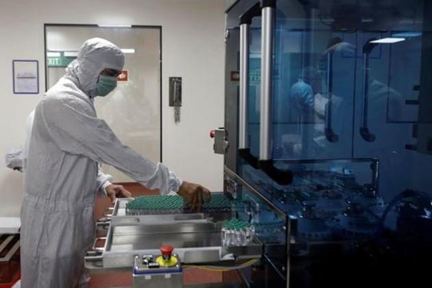An employee in personal protective equipment (PPE) removes vials of AstraZeneca's COVISHIELD, coronavirus disease (COVID-19) vaccine from a visual inspection machine inside a lab at Serum Institute of India, in Pune. (REUTERS) An employee in personal protective equipment (PPE) removes vials of AstraZeneca's COVISHIELD, coronavirus disease (COVID-19) vaccine from a visual inspection machine inside a lab at Serum Institute of India, in Pune. (REUTERS)
